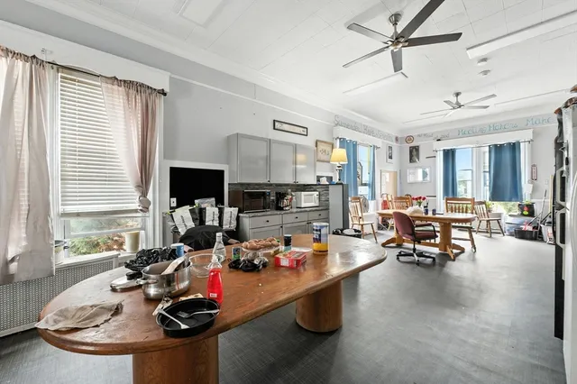 a living room with furniture kitchen view and a window