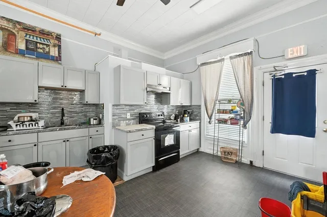 a kitchen with stainless steel appliances kitchen island granite countertop a refrigerator and a stove top oven
