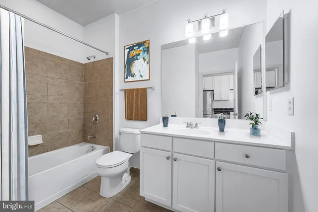 a bathroom with a toilet a sink a tub and mirror