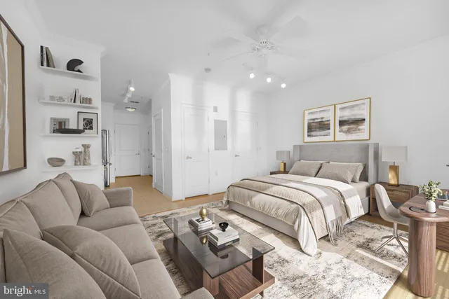 a spacious bedroom with a bed couches and kitchen view