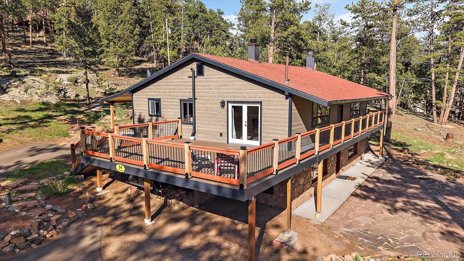 a view of a house with a wooden deck and a yard