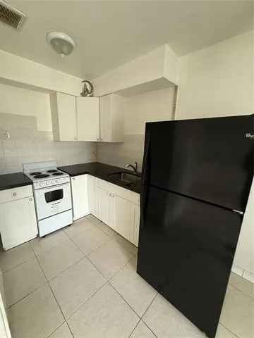 a kitchen with a refrigerator and a stove top oven