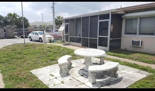 a view of a chair and table in backyard of the house