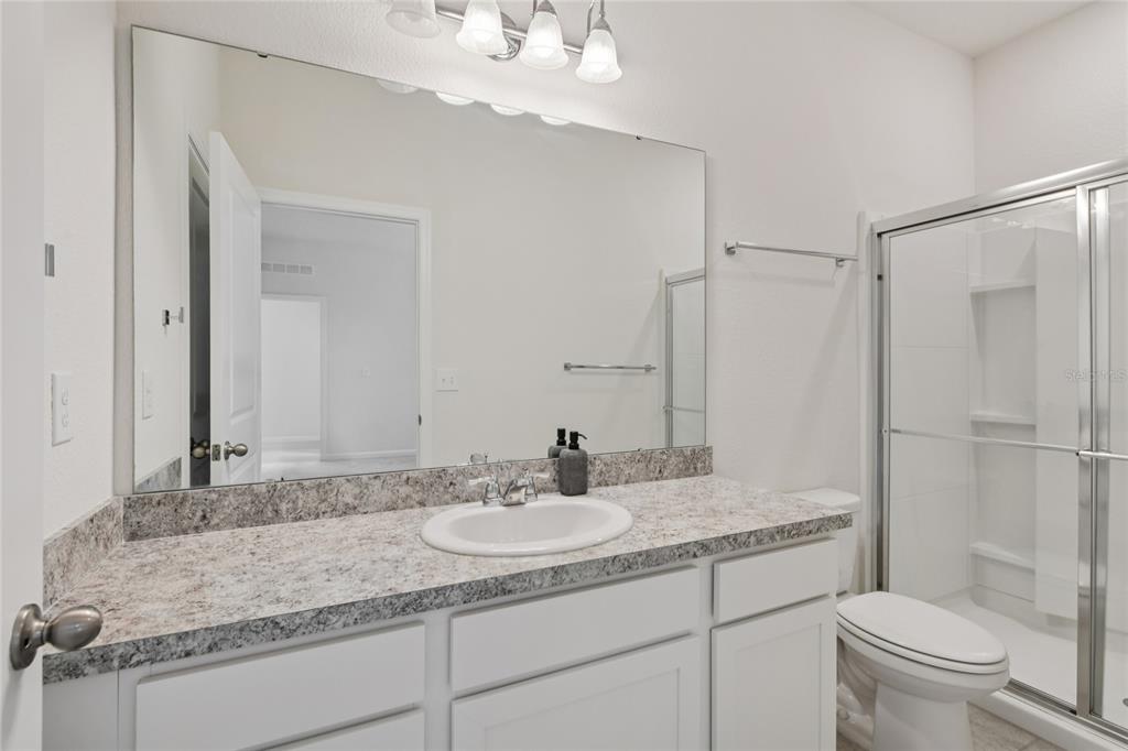 2352 Litchfield Loop DeLand, FL 32720 - Photo 14 of 24 a bathroom with a granite countertop sink a toilet a mirror and shower