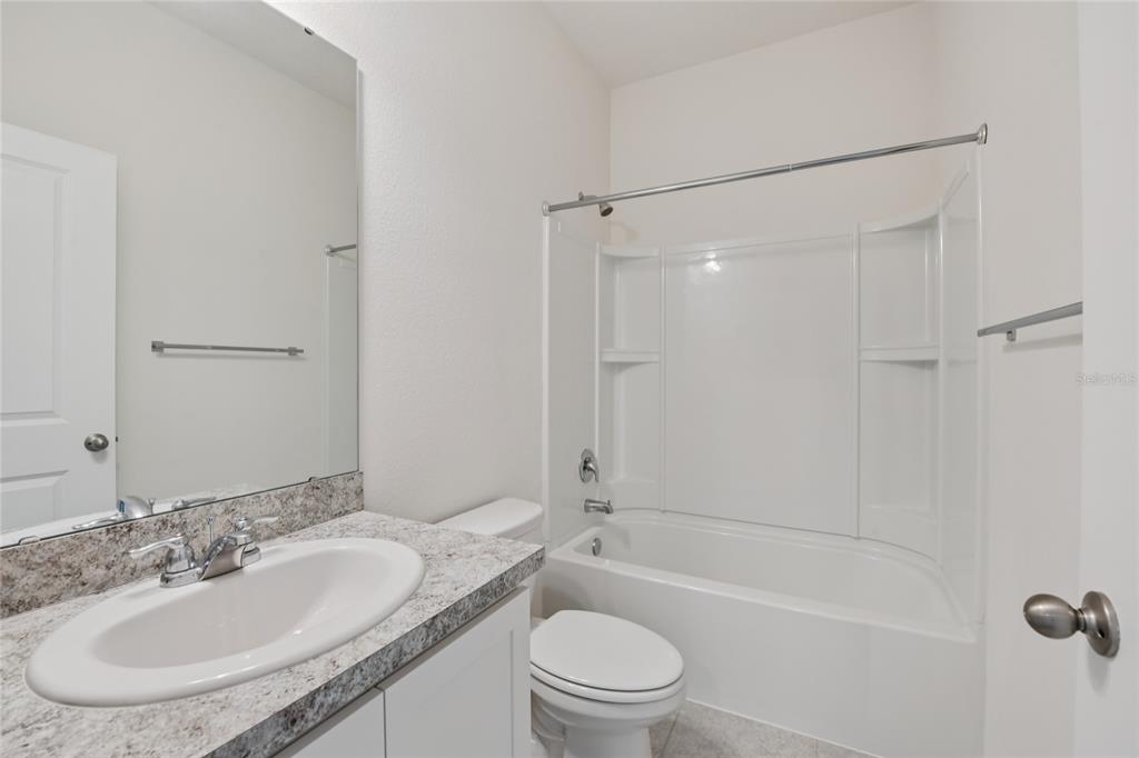 2352 Litchfield Loop DeLand, FL 32720 - Photo 17 of 24 a bathroom with a granite countertop sink toilet and shower