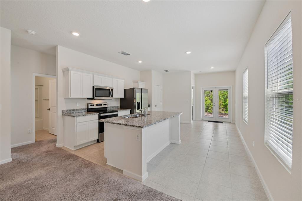 2352 Litchfield Loop DeLand, FL 32720 - Photo 6 of 24 a kitchen with white cabinets and stainless steel appliances