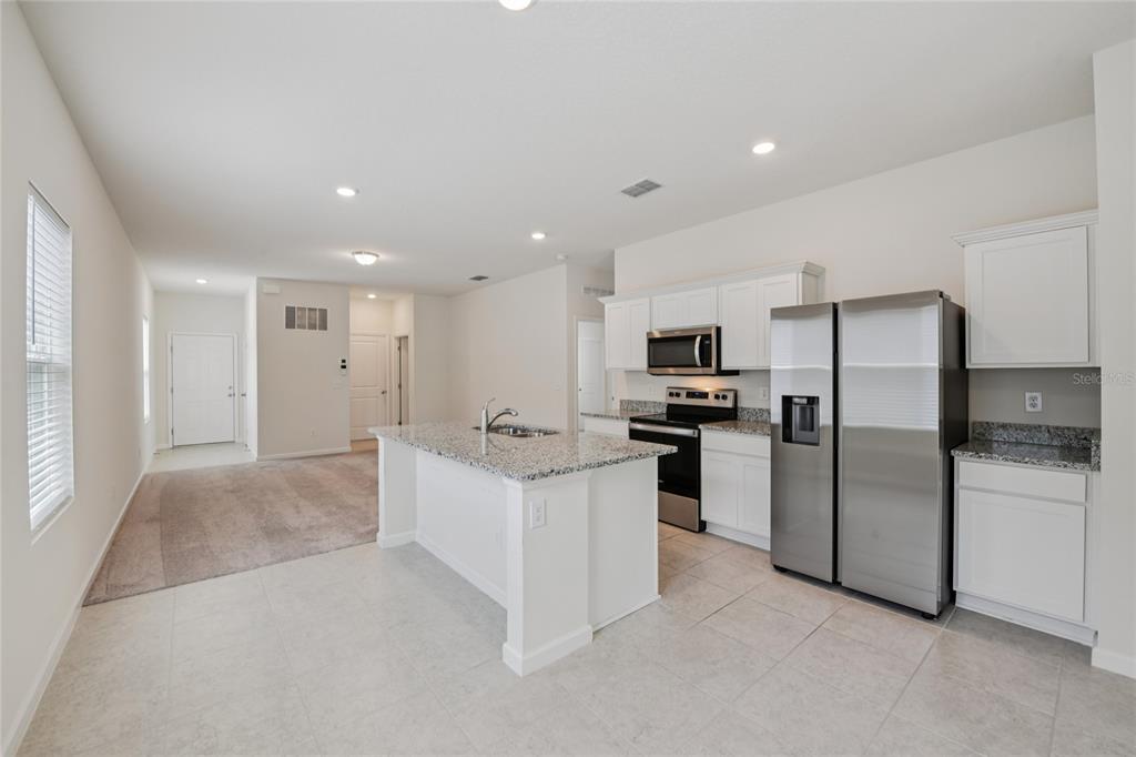 2352 Litchfield Loop DeLand, FL 32720 - Photo 7 of 24 a kitchen with white cabinets and stainless steel appliances