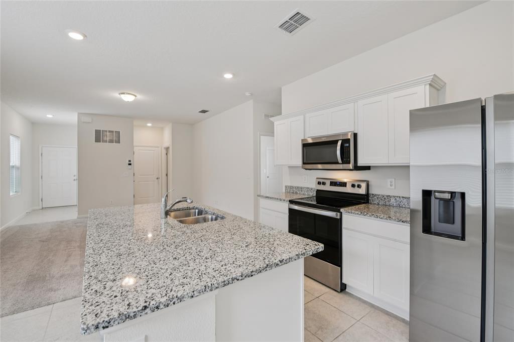 2352 Litchfield Loop DeLand, FL 32720 - Photo 9 of 24 a kitchen with a refrigerator and a sink