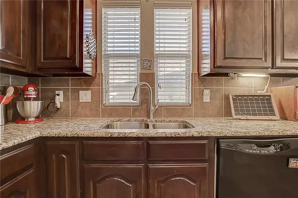 a kitchen with granite countertop cabinets sink and window