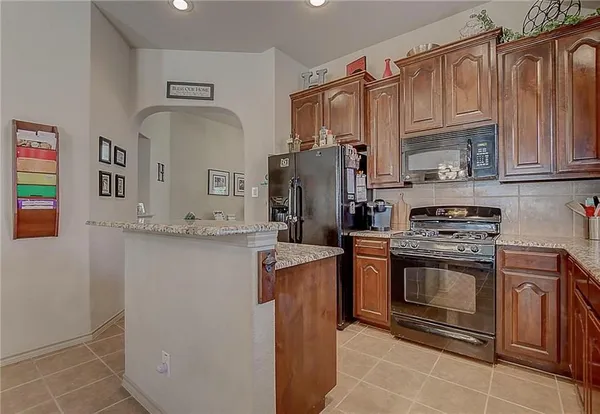 a kitchen with stainless steel appliances granite countertop a refrigerator stove and sink