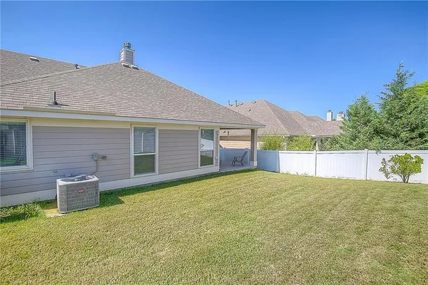 a view of a house with a yard and potted plants