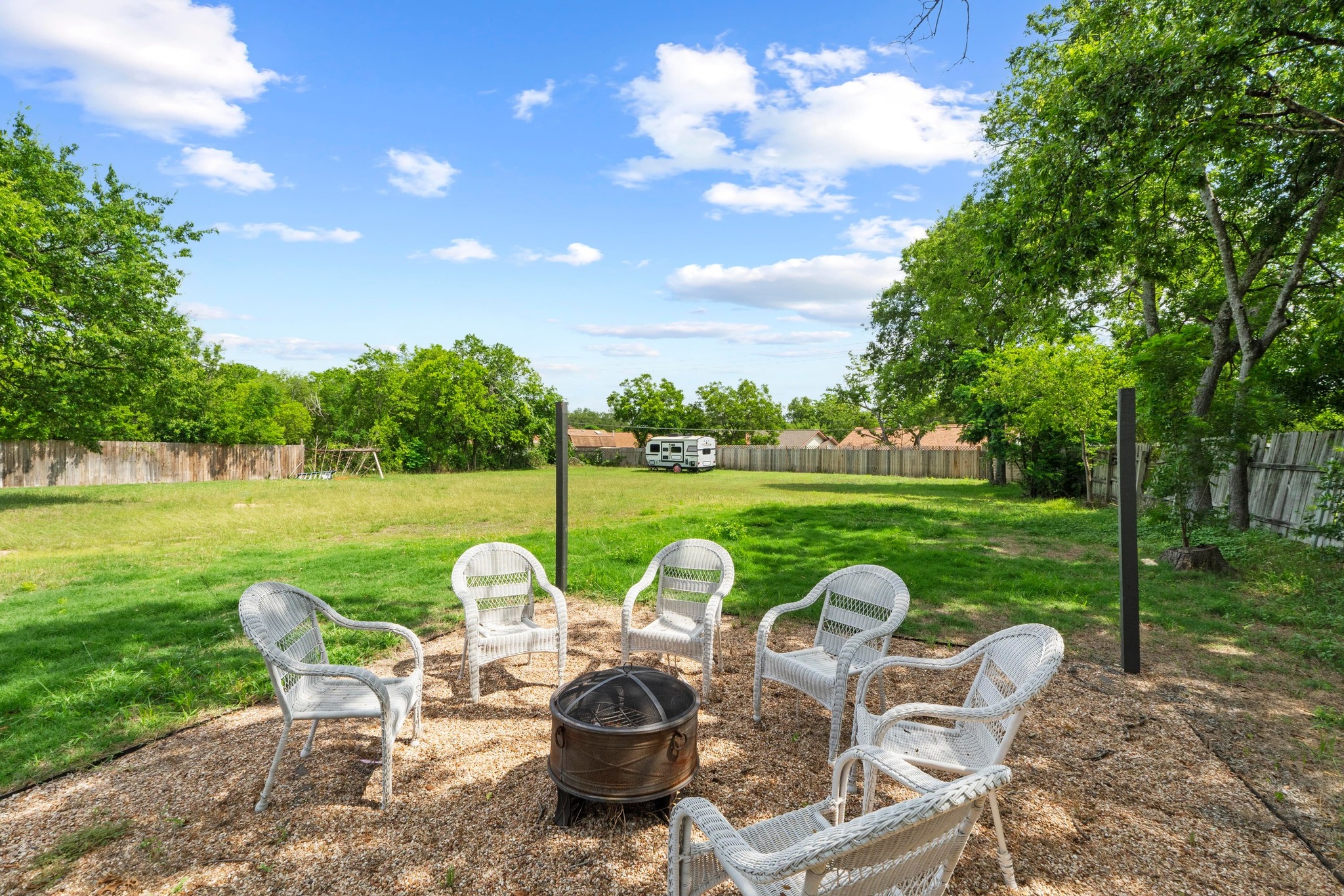 10601 Macmora Road, Unit B Austin, TX 78758 - Photo 19 of 22 A spacious backyard with mature trees, a private fence, and a designated fire pit area for outdoor gatherings.