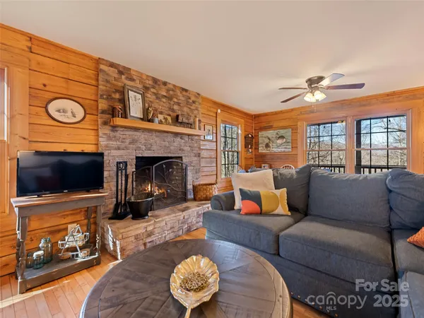 a living room with furniture a fireplace and wooden floor