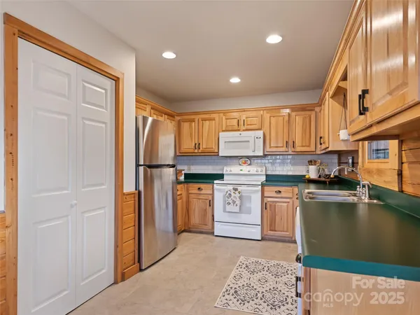 a kitchen with stainless steel appliances granite countertop a stove a sink and a microwave