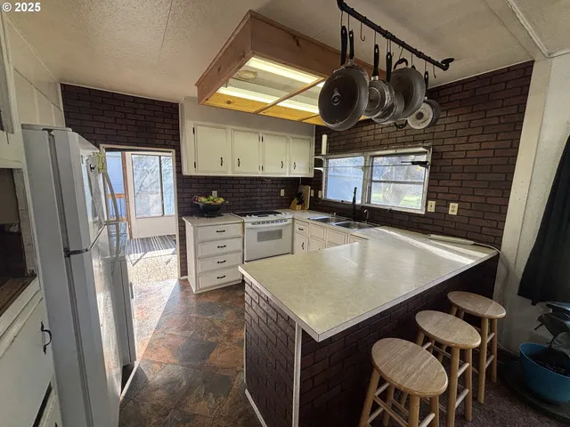 a kitchen with stainless steel appliances granite countertop a sink a stove and a refrigerator