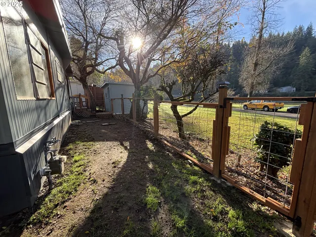 a view of a yard with wooden fence