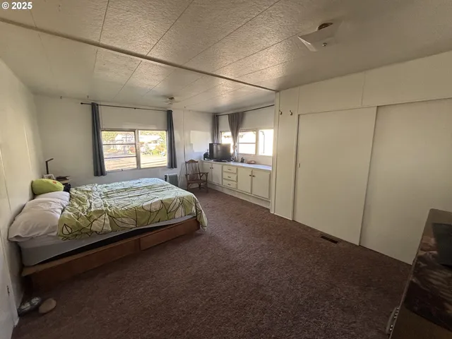 a spacious bedroom with a bed and a window