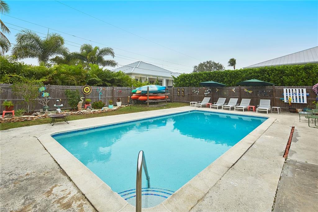 1343 12th Street North Naples, FL 34102 - Photo 14 of 18 a view of a swimming pool with lawn chairs