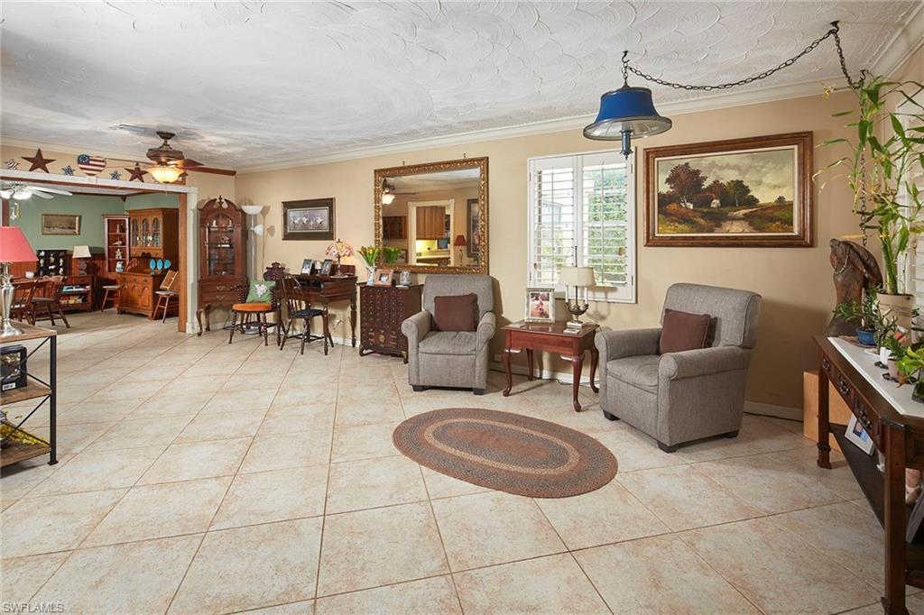 1343 12th Street North Naples, FL 34102 - Photo 2 of 18 a living room with furniture a flat screen tv and large window