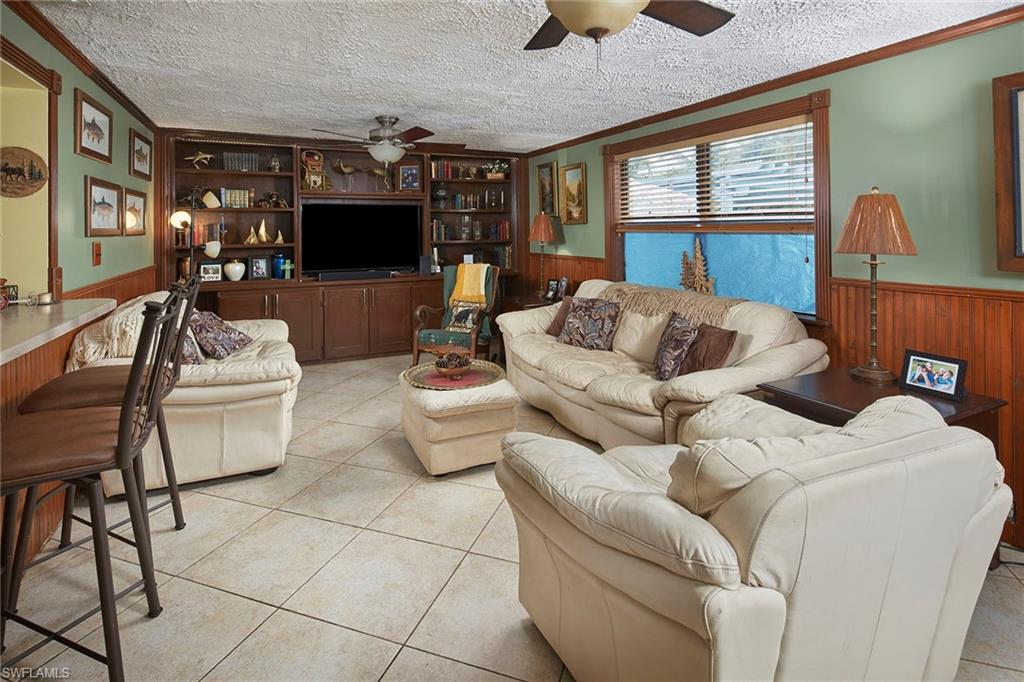 1343 12th Street North Naples, FL 34102 - Photo 6 of 18 a living room with furniture a flat screen tv and a large window