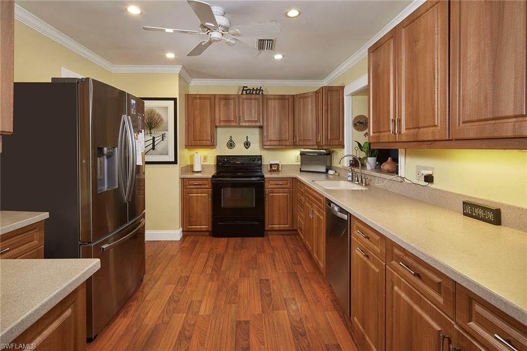 1343 12th Street North Naples, FL 34102 - Photo 7 of 18 a kitchen with stainless steel appliances a refrigerator sink and cabinets