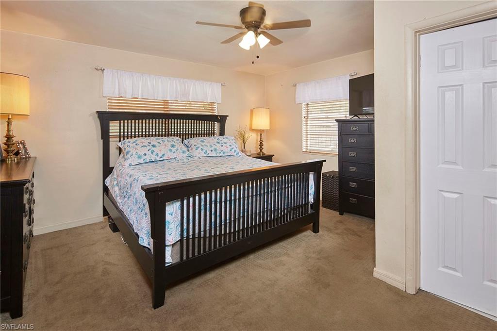 1343 12th Street North Naples, FL 34102 - Photo 8 of 18 a bedroom with a bed and a chandelier