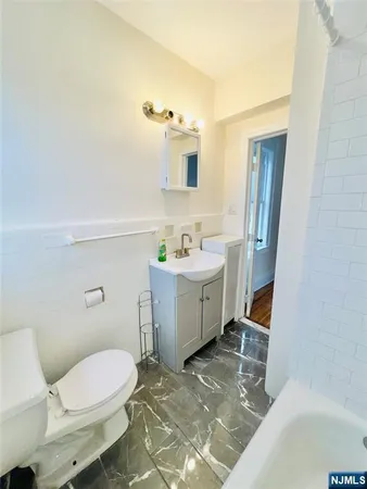 a bathroom with a sink toilet and mirror