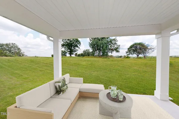 a view of a patio with lawn chairs plants and ocean view