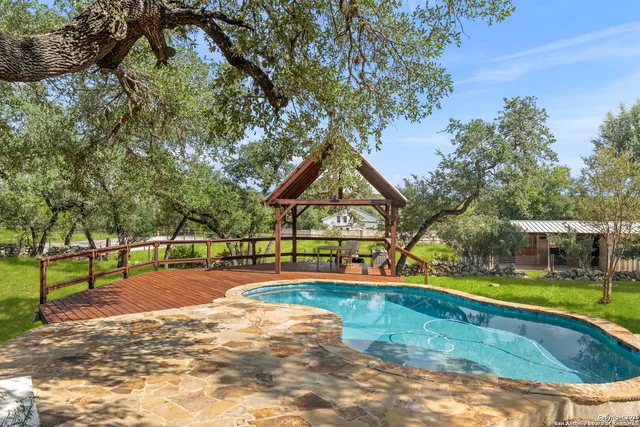 a view of swimming pool with trees and sitting area