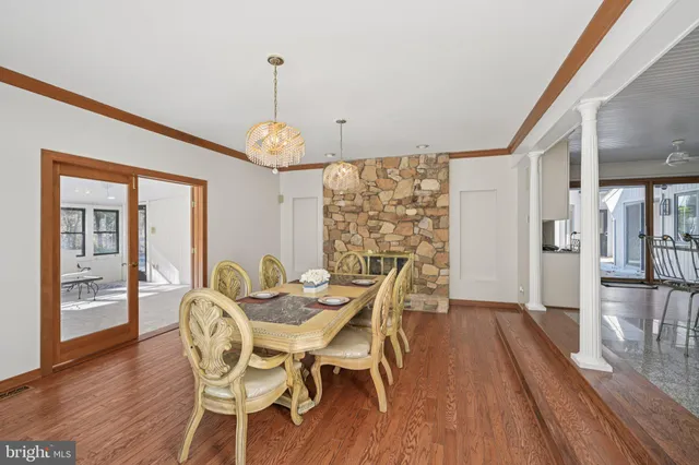 a kitchen with stainless steel appliances granite countertop a stove top oven a sink a dining table and chairs