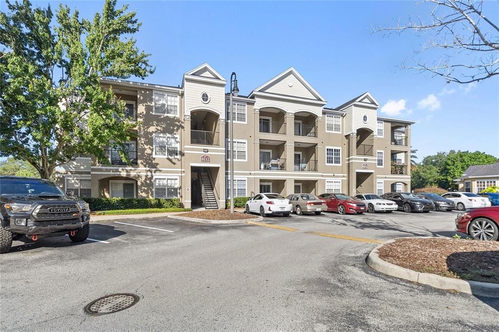 a front view of a building with cars parked
