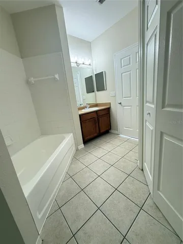 a bathroom with a tub a sink and a mirror