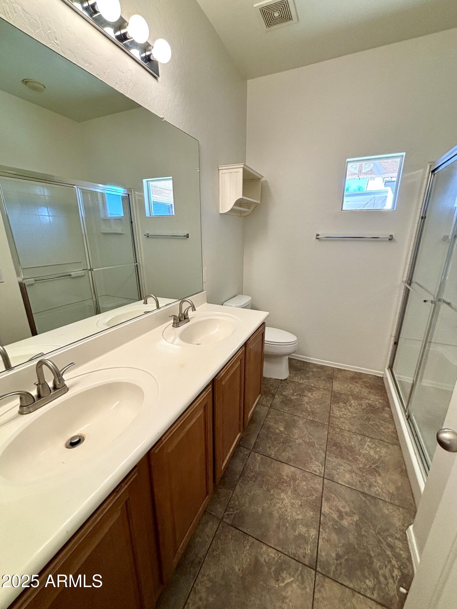 5139 West Maldonado Road Laveen, AZ 85339 - Photo 16 of 39 a spacious bathroom with a sink a mirror and a toilet