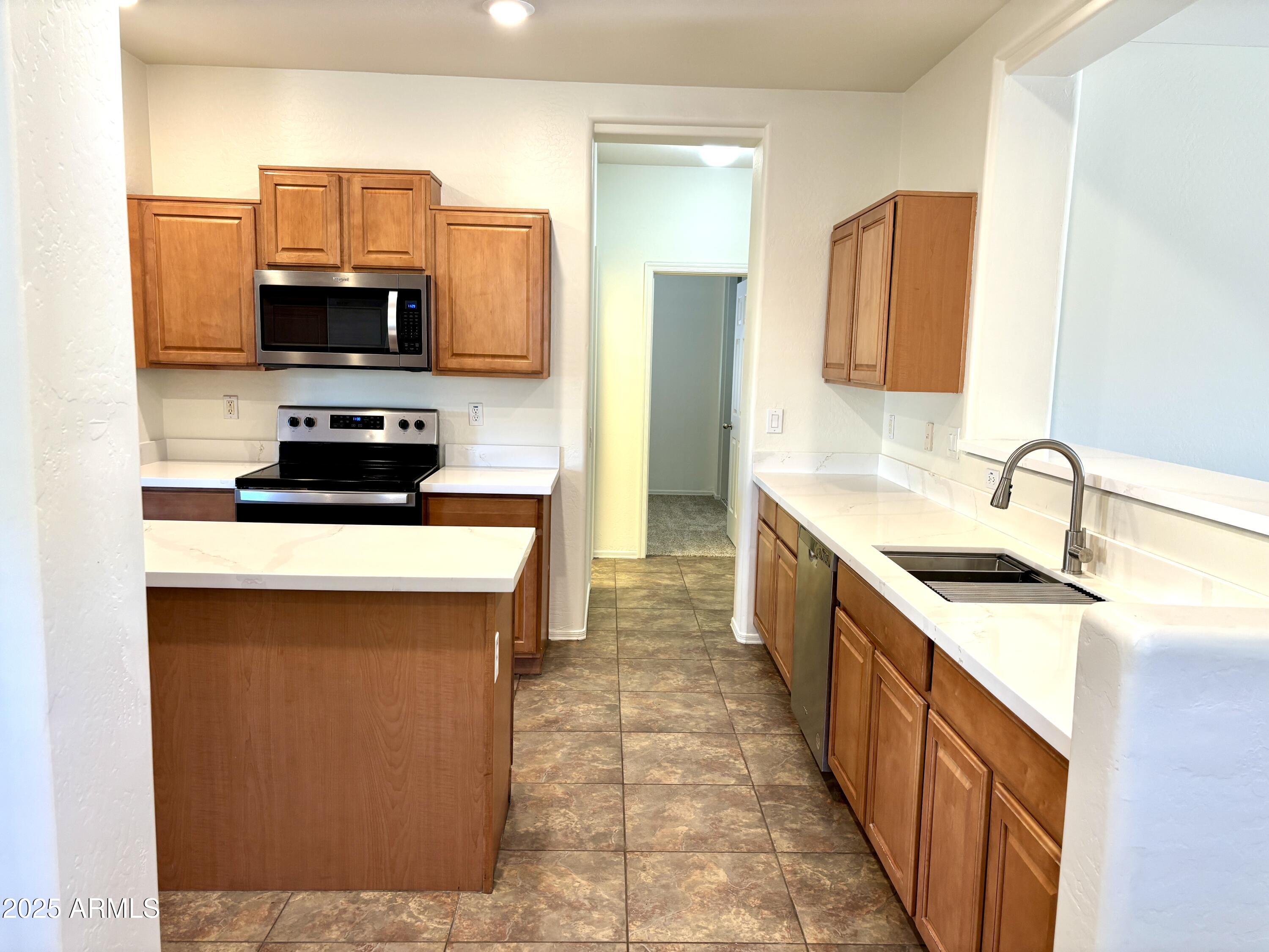 5139 West Maldonado Road Laveen, AZ 85339 - Photo 8 of 39 a kitchen with stainless steel appliances a sink stove and refrigerator