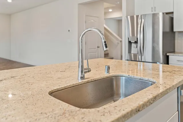 a view of a kitchen counter top a sink and refrigerator