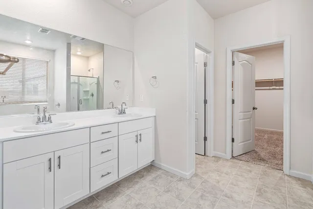 a spacious bathroom with double sink and a mirror