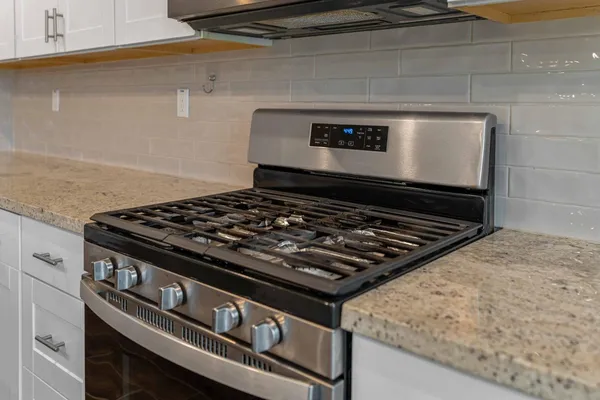 a stove sitting inside of a kitchen with granite countertop