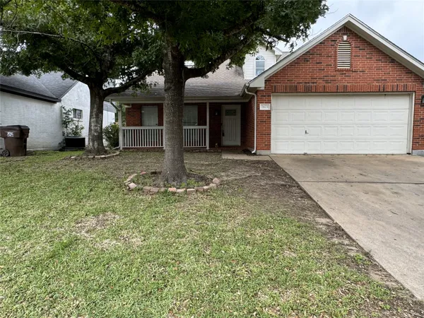 a front view of a house with a garden and yard