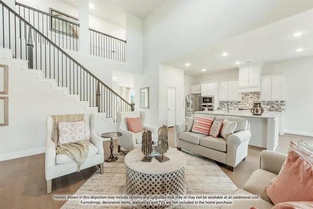 a living room with furniture kitchen view and a wooden floor