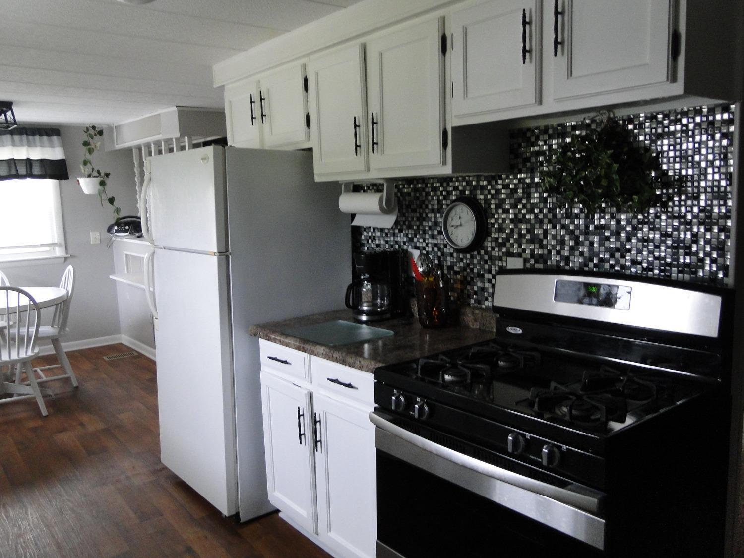 612 West 100 South Hebron, IN 46341 - Photo 7 of 18 a kitchen with a stove and white cabinets
