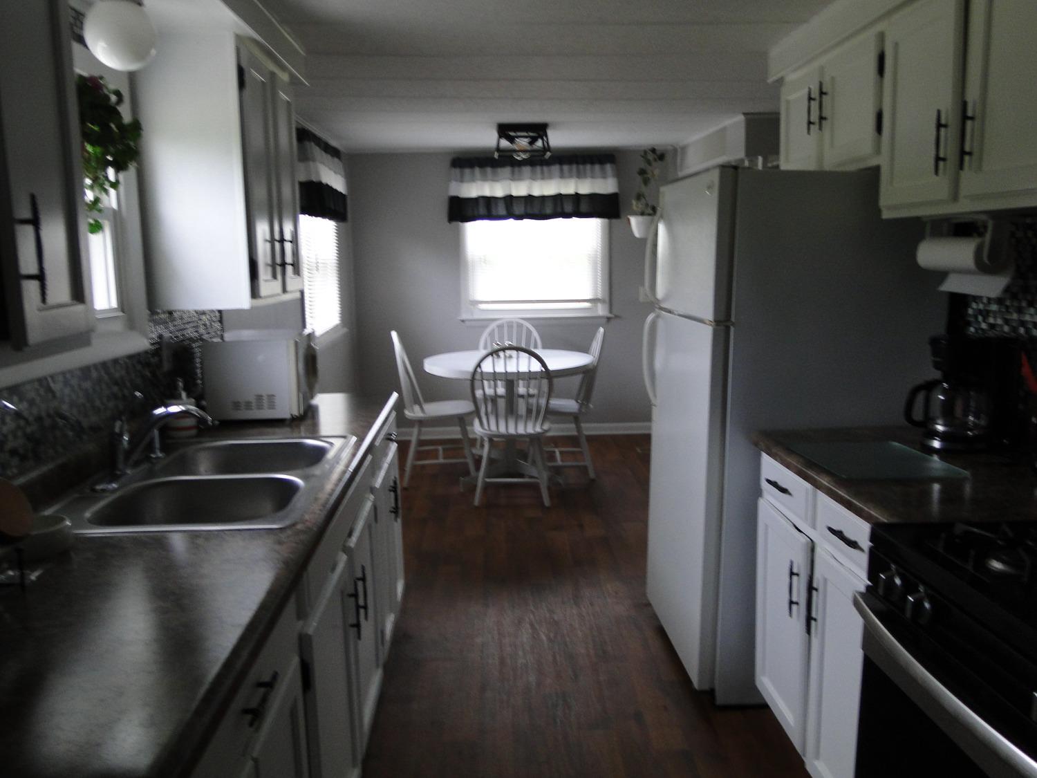 612 West 100 South Hebron, IN 46341 - Photo 8 of 18 a kitchen with granite countertop a sink stove and refrigerator