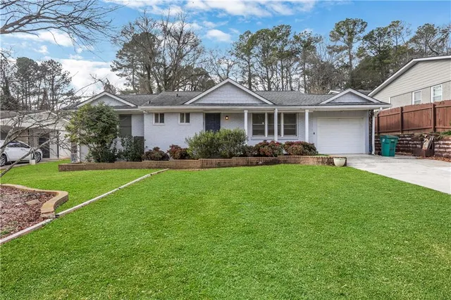 a front view of a house with a garden and trees