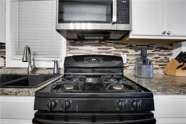 a stove top oven sitting inside of a kitchen