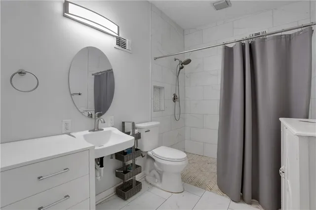 a bathroom with a sink toilet a mirror and shower