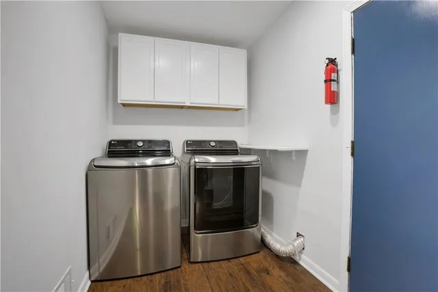 a utility room with wooden floor washer and dryer