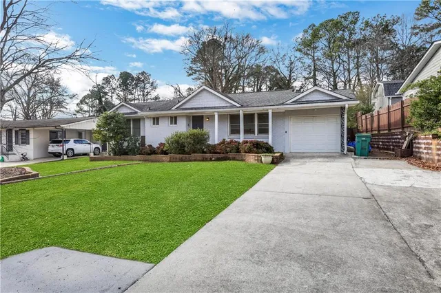 a front view of a house with a garden and trees