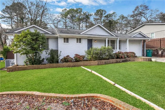 a front view of a house with a garden and plants
