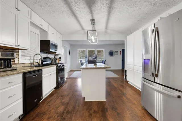 a large kitchen with cabinets wooden floor and stainless steel appliances