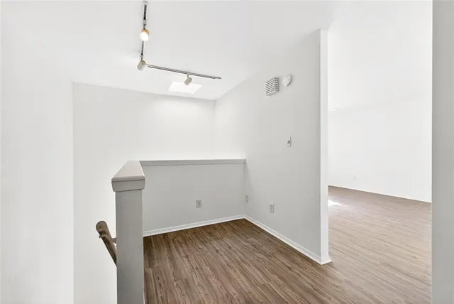 a view of a room with wooden floor and fan