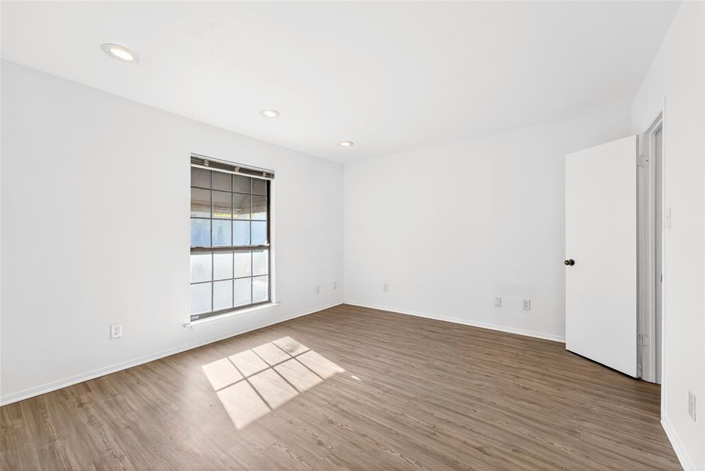 4338 Hartford Street, Unit 7 Dallas, TX 75219 - Photo 12 of 23 an empty room with wooden floor and windows